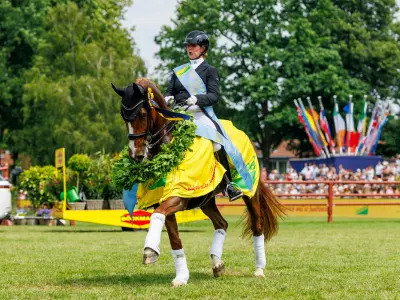 Siegerin reitet auf ihrem Pferd beim Hamburger Derby