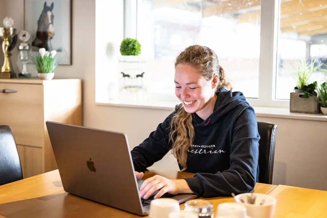 Junge Frau sitzt an einem MacBook.