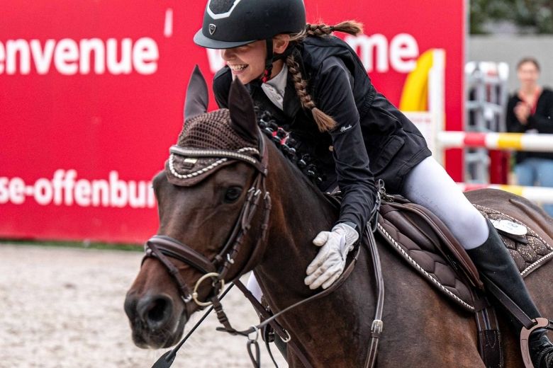 eurocheval: Mädchen reitet im Galopp durch die Arena und lacht