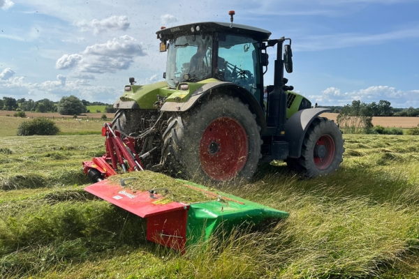 Heu trocknen: Traktor mäht Wiese