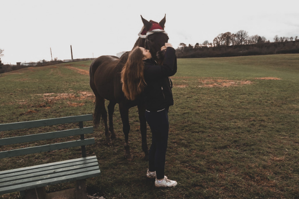 Frau küsst Pferd