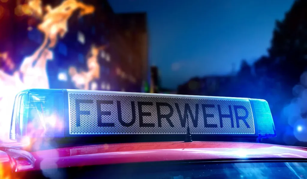 Ein Feuerwehrauto und im Hintergrund sind Flammen