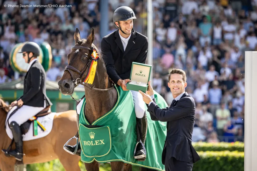 The photo shows the dream team that secured victory at the 2026 Rolex Grand Prix at TSCHIO Aachen: Richard Vogel and United Touch S. Standing beside them is Rémi Corpataux, CEO of Rolex Deutschland GmbH