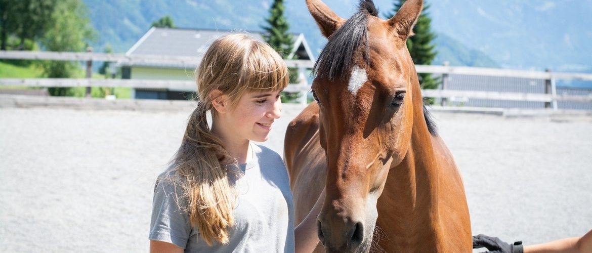Kinder und Pferde: Mädchen mit Pferd auf der Koppel
