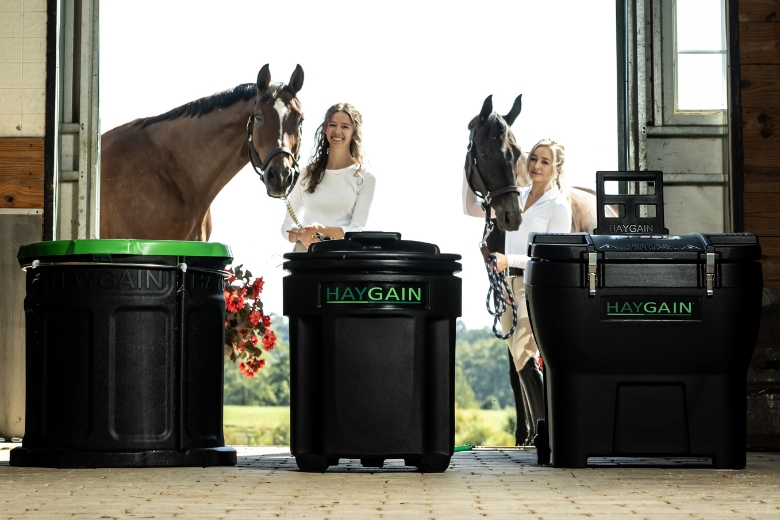 Pferd hustet: Pferde stehen in Stallgasse, davor Heubedampfer von Haygain